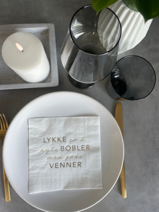 Hvit serviett med gull tekst - Lykken er....