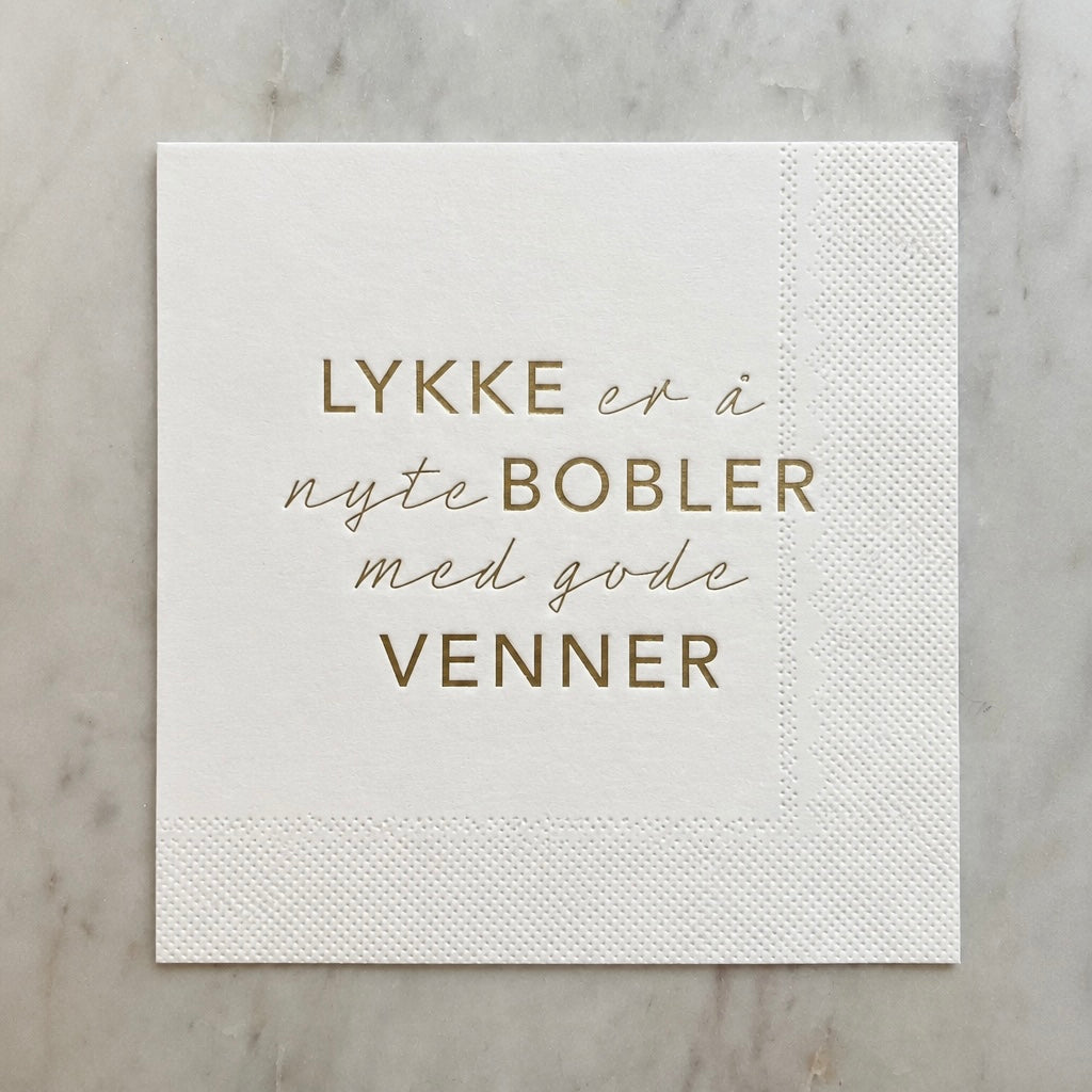 Hvit serviett med gull tekst - Lykken er....