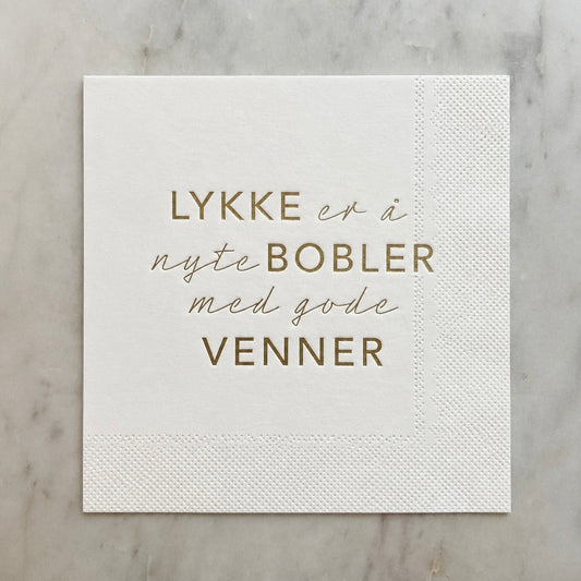 Hvit serviett med gull tekst - Lykken er....