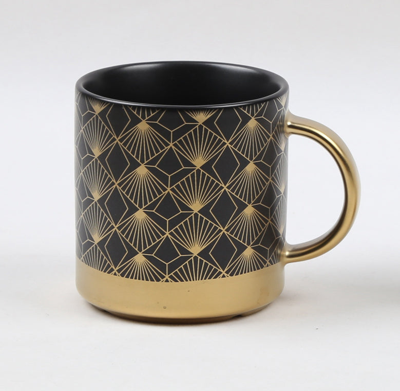 Sort kopp med gullmønster